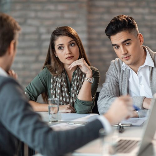 Young couple talking to their insurance agent while having consultations in the office.